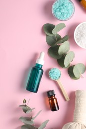 Photo of Different aromatherapy products and eucalyptus branches on pink background, flat lay