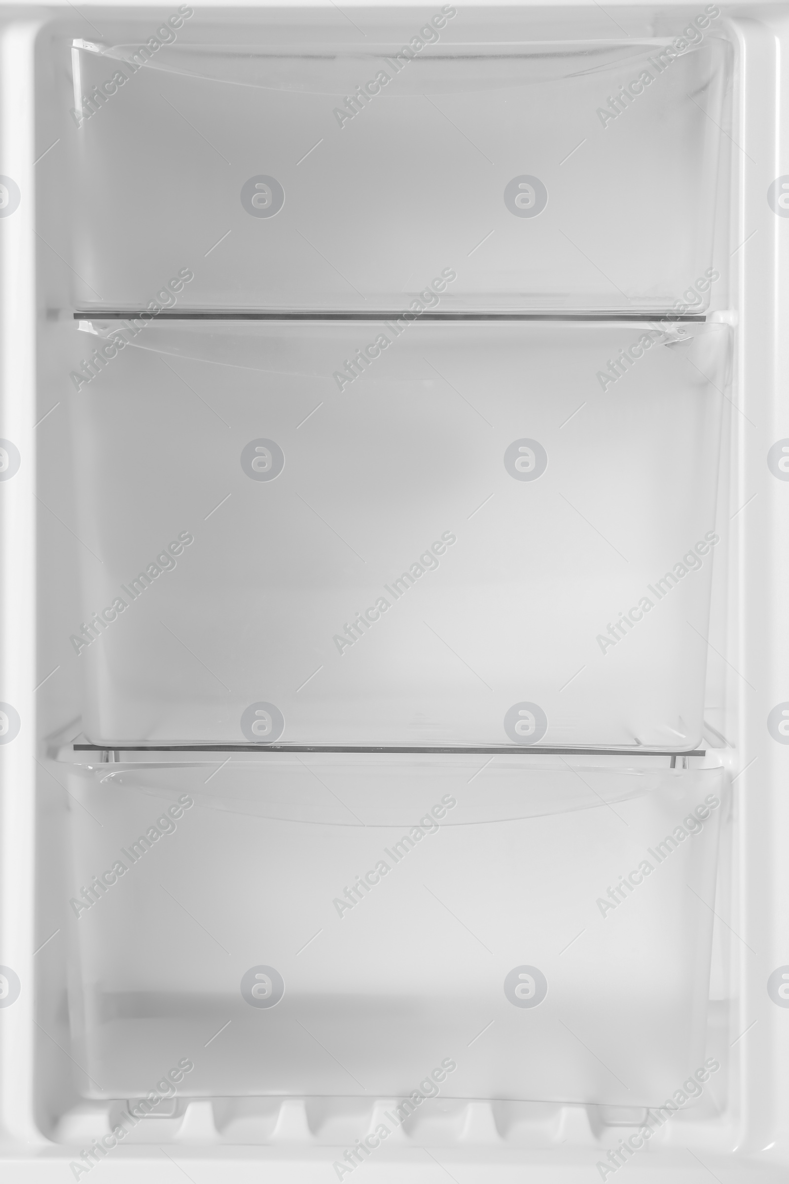 Photo of Modern open refrigerator with empty shelves, closeup