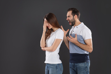 Photo of Man shouting at his girlfriend on black background. Relationship problems