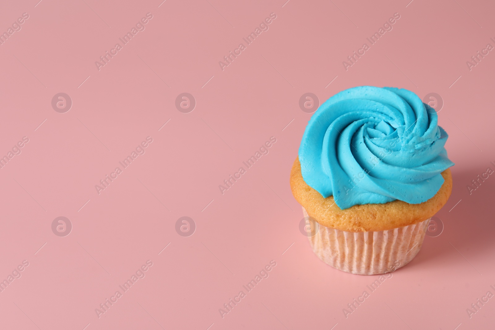 Photo of Delicious cupcake with bright cream on pink background, space for text