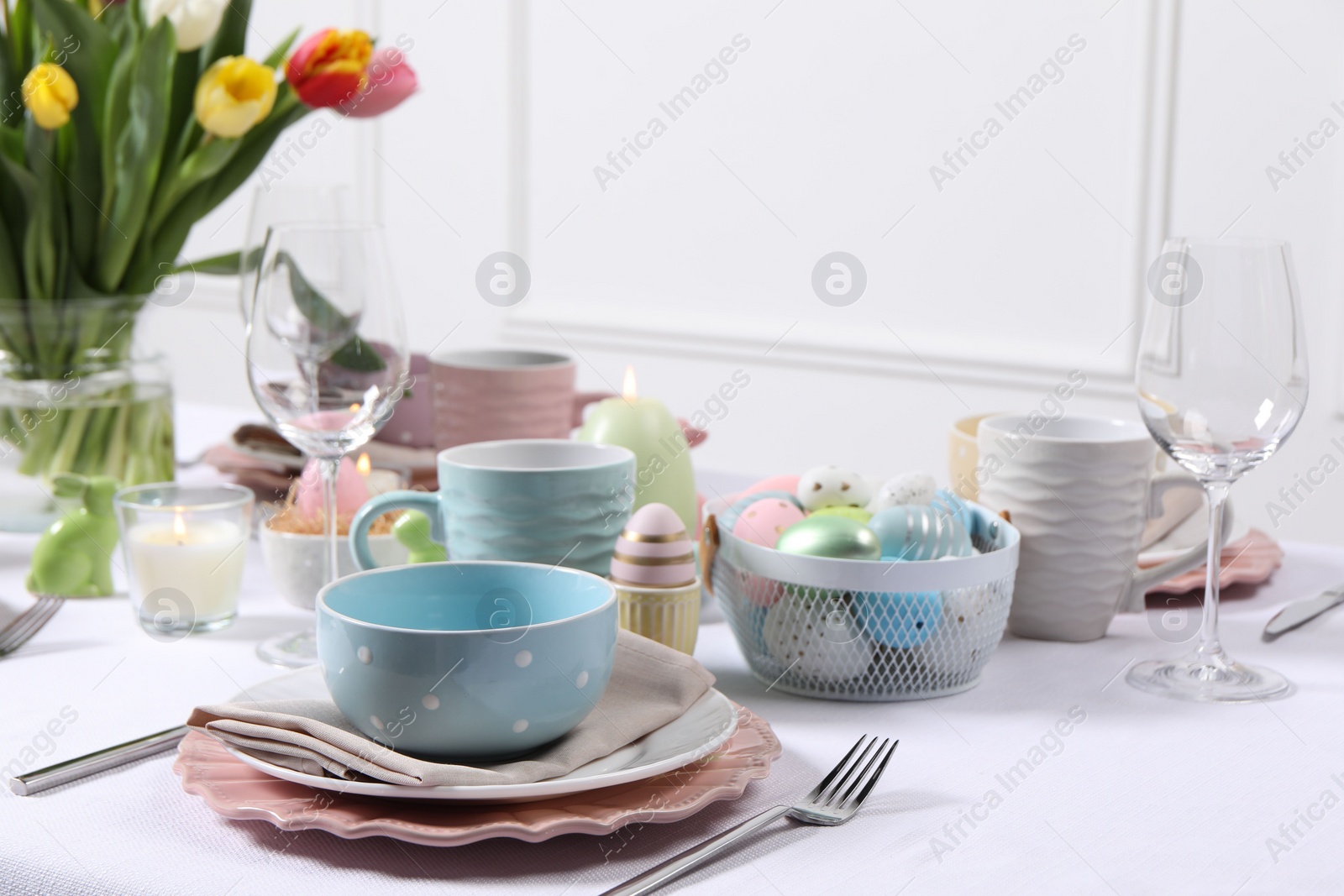 Photo of Festive table setting with painted eggs. Easter celebration