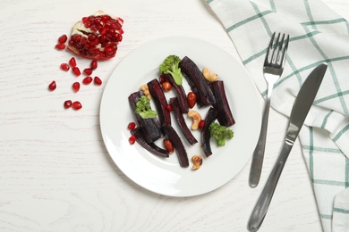 Photo of Tasty raw black carrot served on white wooden table, flat lay