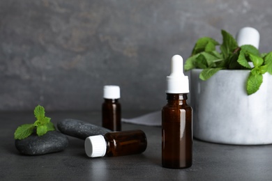 Composition with essential oil in glass bottles on table