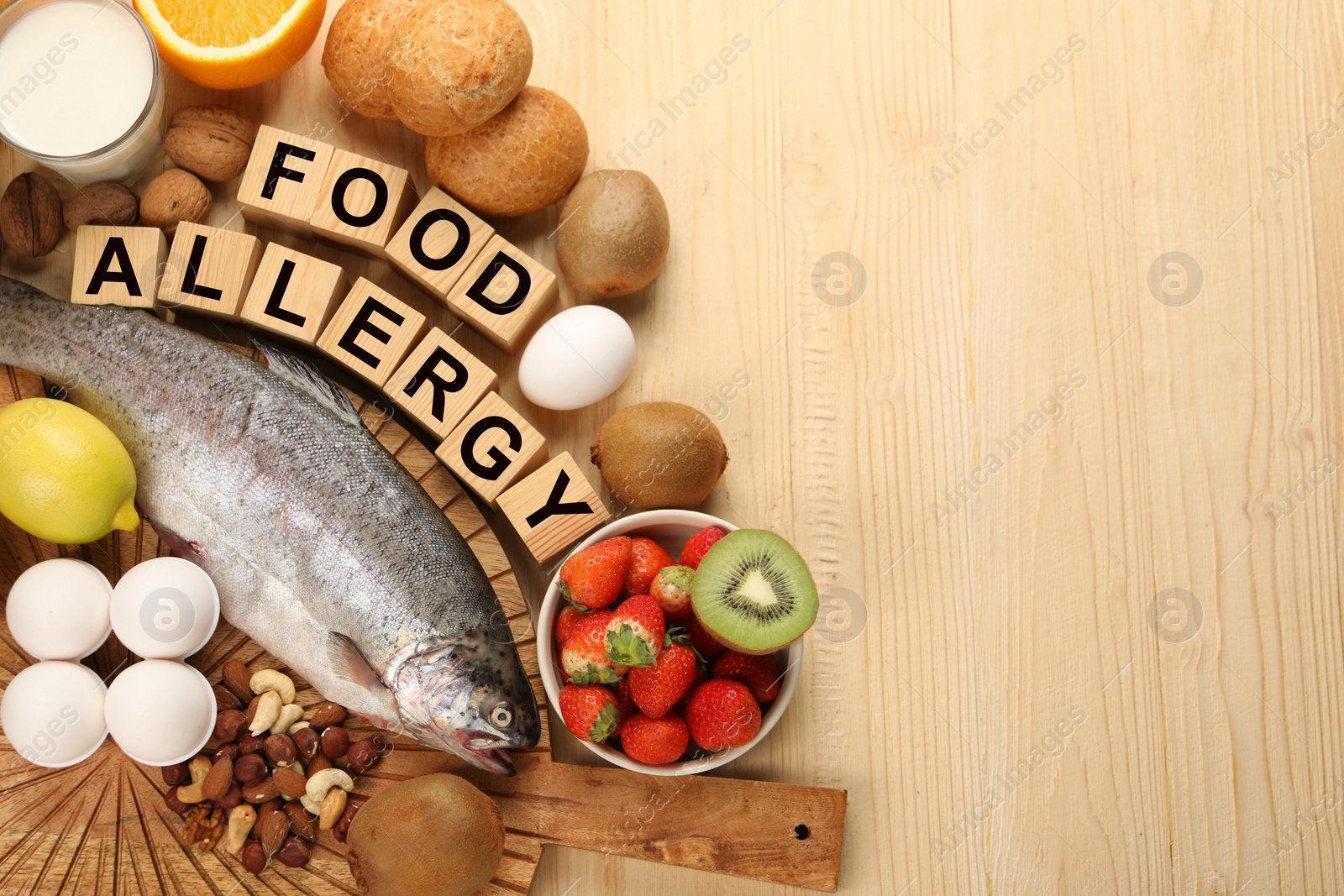 Image of Food allergy. Different fresh products and cubes on wooden table, flat lay with space for text