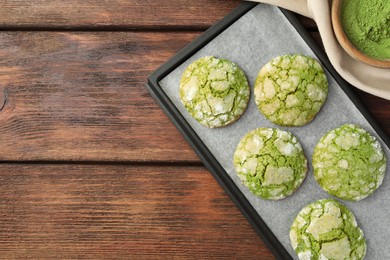 Baking tray with tasty matcha cookies and powder on wooden table, flat lay. Space for text