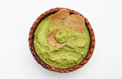 Delicious guacamole made of avocados with chips on white background, top view