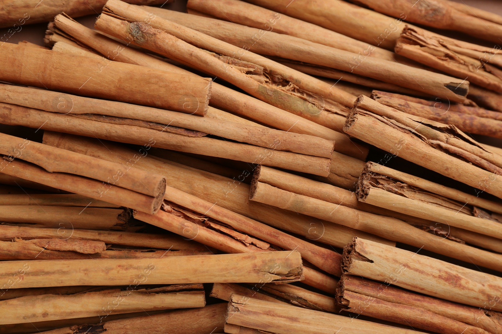 Photo of Aromatic cinnamon sticks as background, top view