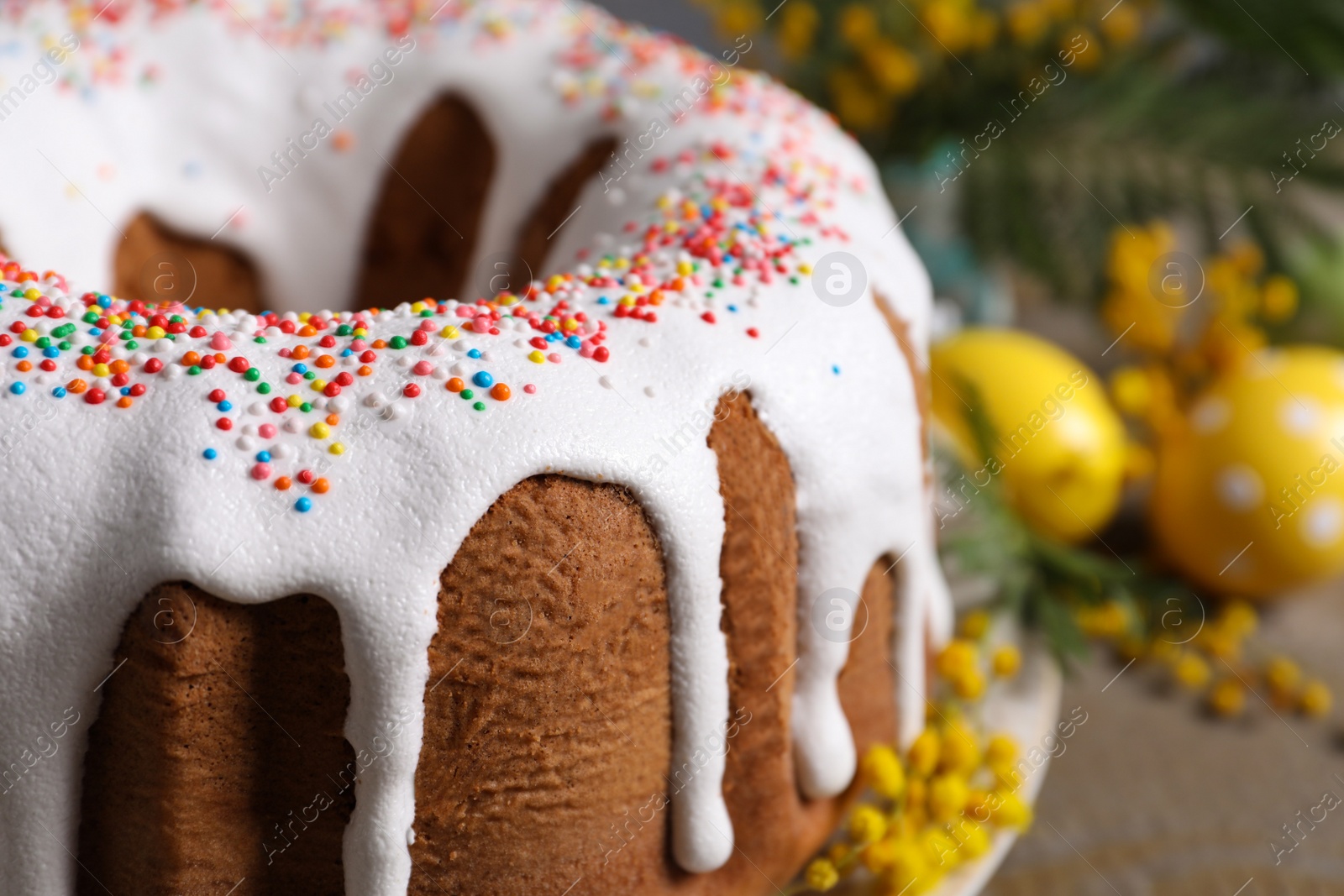 Photo of Glazed Easter cake with sprinkles on table, closeup. Space for text