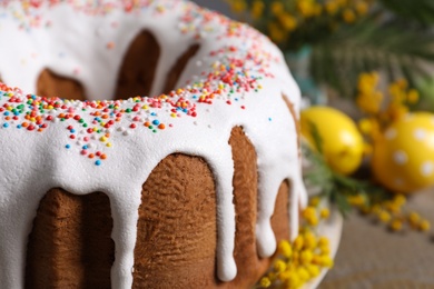 Photo of Glazed Easter cake with sprinkles on table, closeup. Space for text