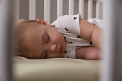 Photo of Adorable little baby sleeping in crib, closeup