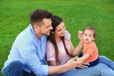 Photo of Happy family with adorable little baby outdoors