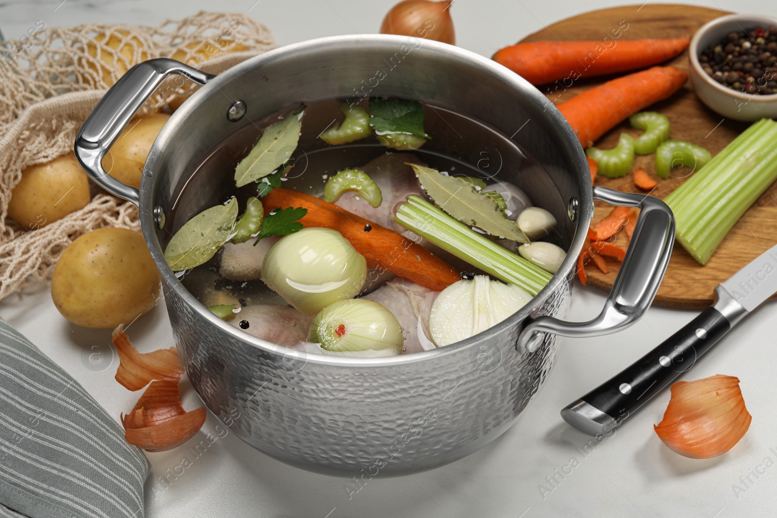 Photo of Pot and different ingredients for cooking tasty bouillon on white table