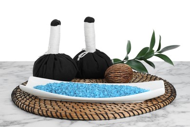 Composition with blue sea salt and herbal bags on marble table against white background