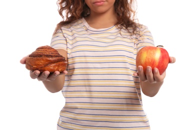 Photo of Young African-American woman with pastry and apple on white background, closeup. Diabetes diet