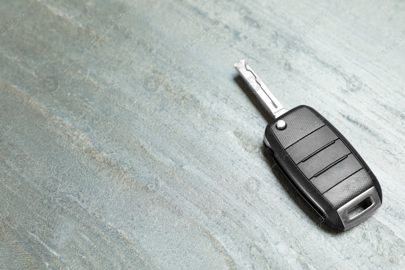 Photo of Car key on grey background. Space for text