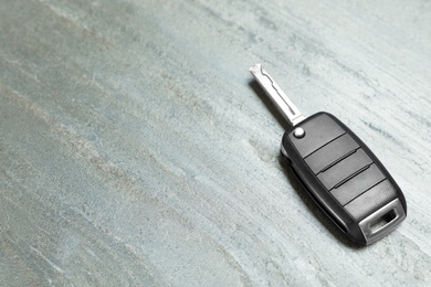 Car key on grey background. Space for text