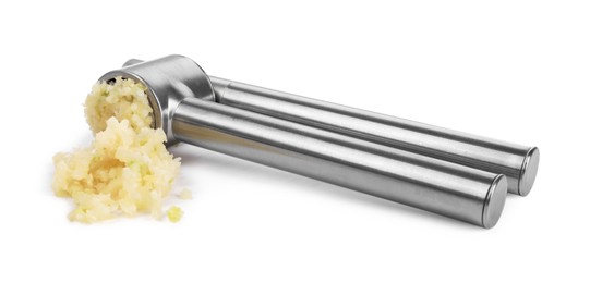 Photo of One metal press and crushed garlic isolated on white