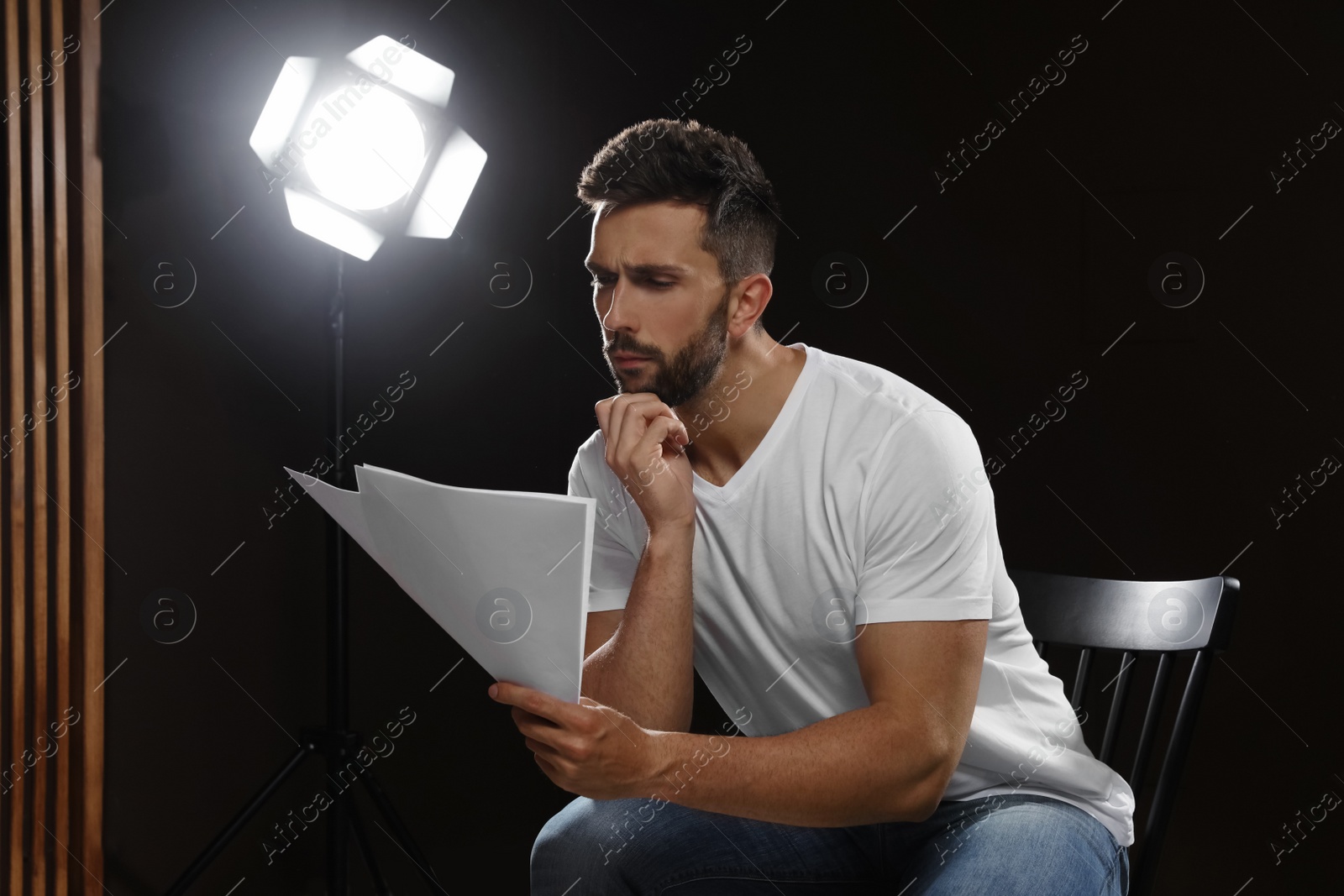 Photo of Professional actor reading his script during rehearsal in theatre