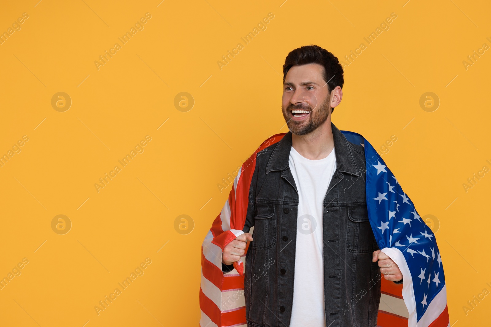 Photo of 4th of July - Independence Day of USA. Happy man with American flag on yellow background, space for text