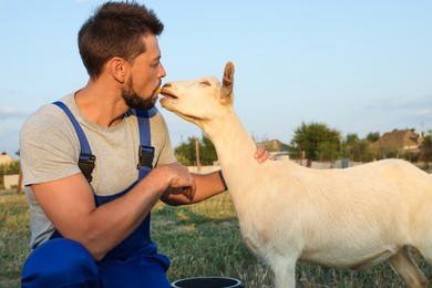 Man feeding goat at farm. Animal husbandry