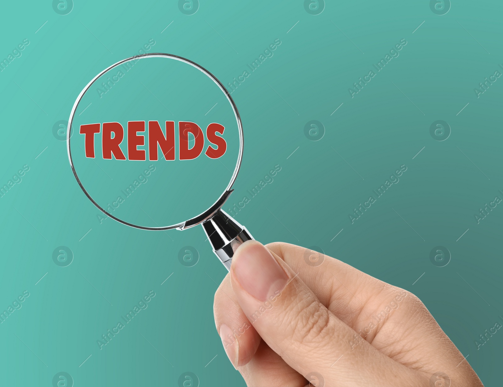 Image of Searching new and popular trends. Woman holding magnifying glass over word on turquoise background, closeup