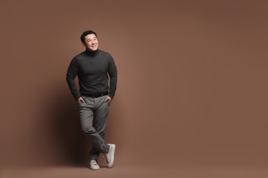 Full length portrait of happy man on brown background. Space for text