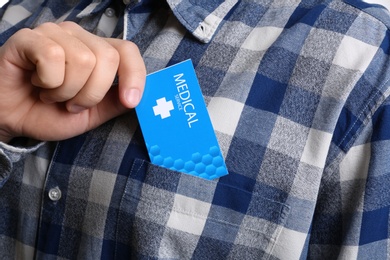 Man putting business card into pocket, closeup. Medical service