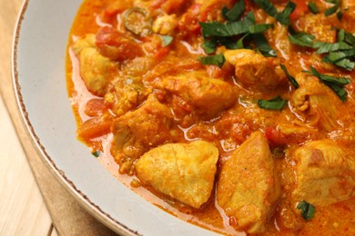 Photo of Delicious chicken curry with parsley on table, closeup