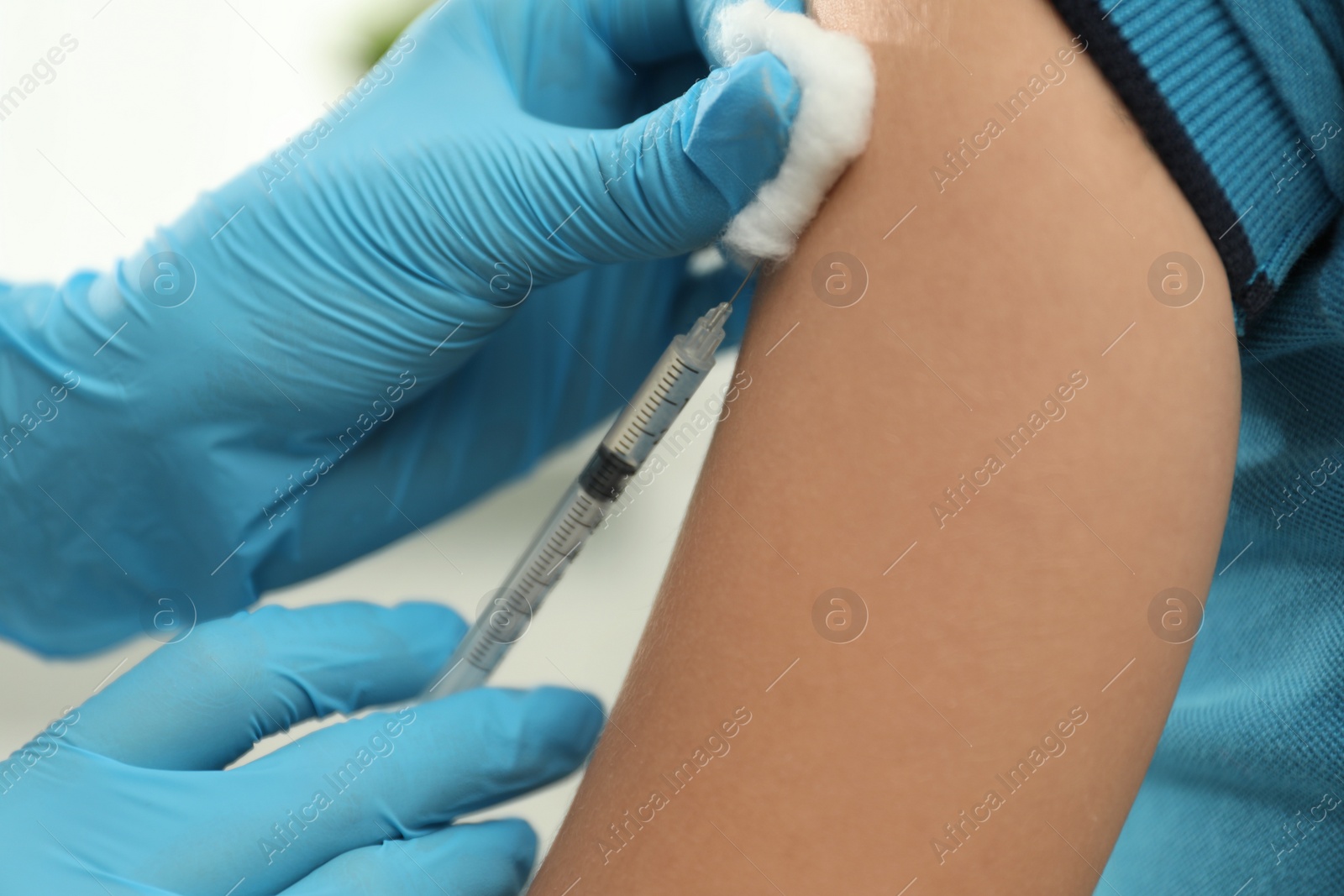 Photo of Doctor vaccinating little child in clinic, closeup