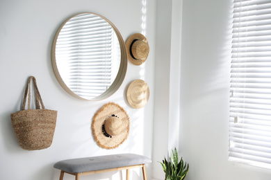 Photo of Stylish round mirror hanging on white wall in room