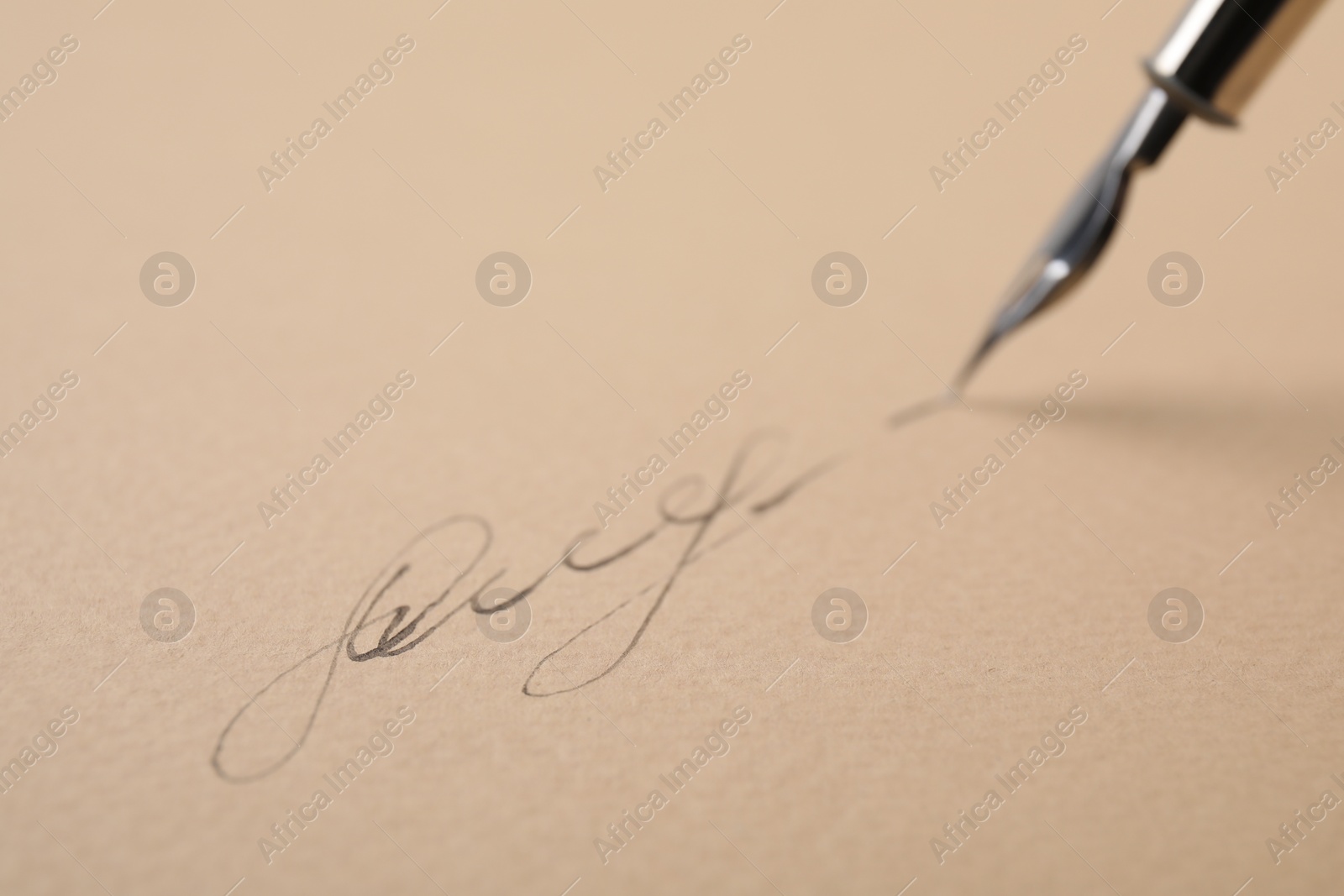 Photo of Signing on sheet of paper with fountain pen, closeup. Space for text