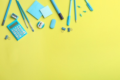 Photo of Blue school stationery on yellow background, flat lay with space for text. Back to school