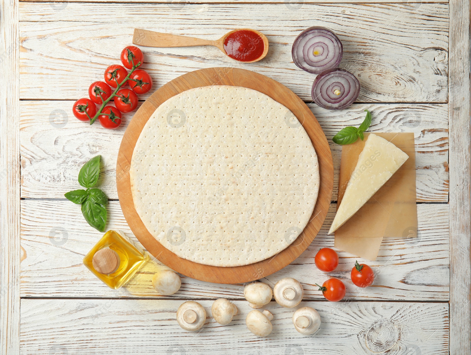 Photo of Flat lay composition with base and ingredients for pizza on wooden table