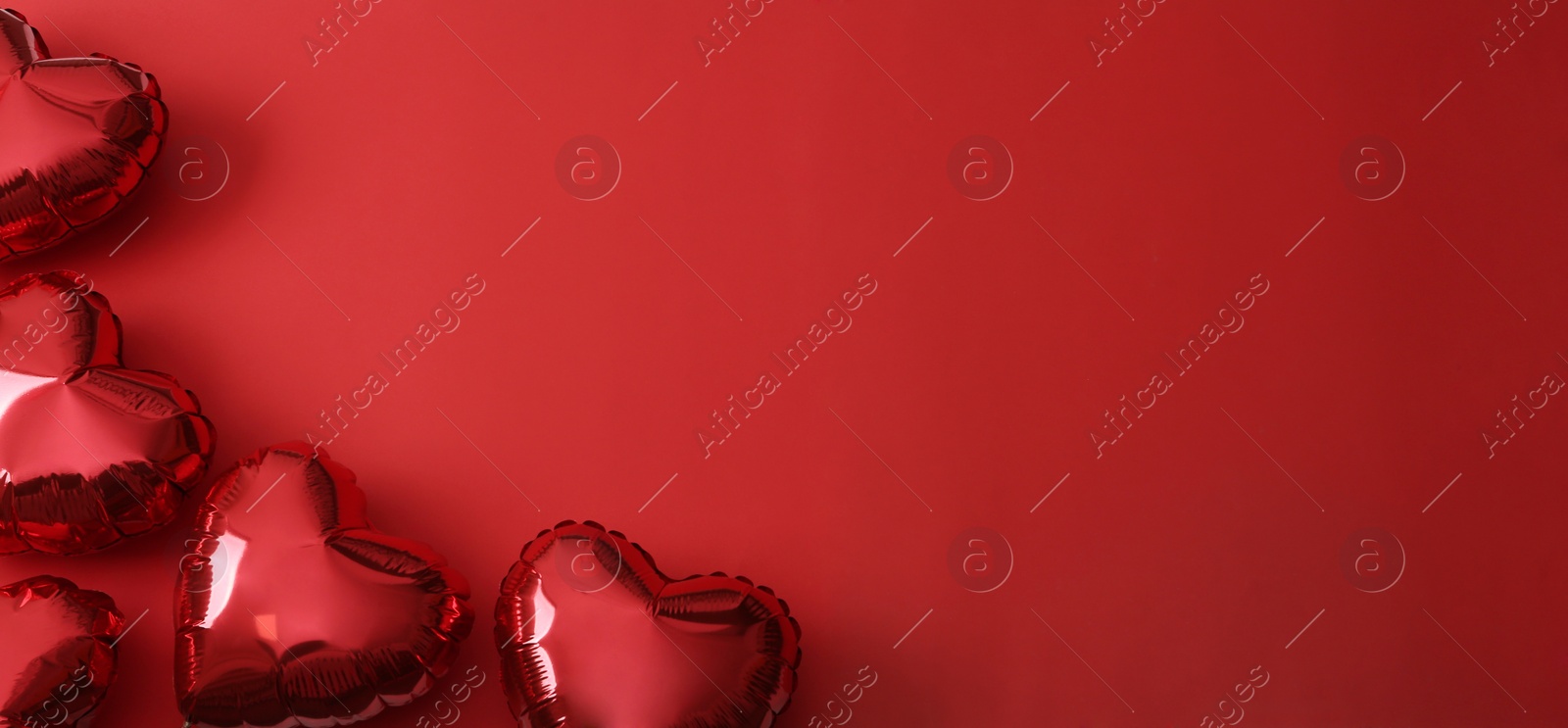 Photo of Heart shaped balloons on red background, flat lay with space for text. Saint Valentine's day celebration