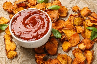 Photo of Sweet potato chips and bowl of sauce on parchment