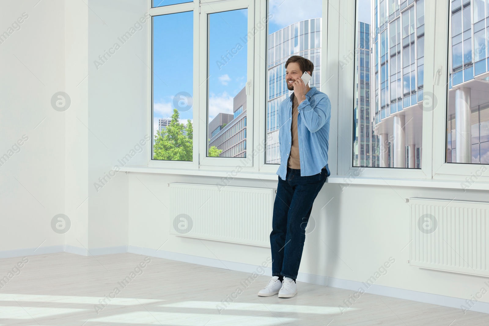 Photo of Man in casual clothes talking on phone indoors, space for text