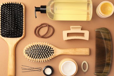 Photo of Flat lay composition with wooden hairbrushes and different cosmetic products on light brown background