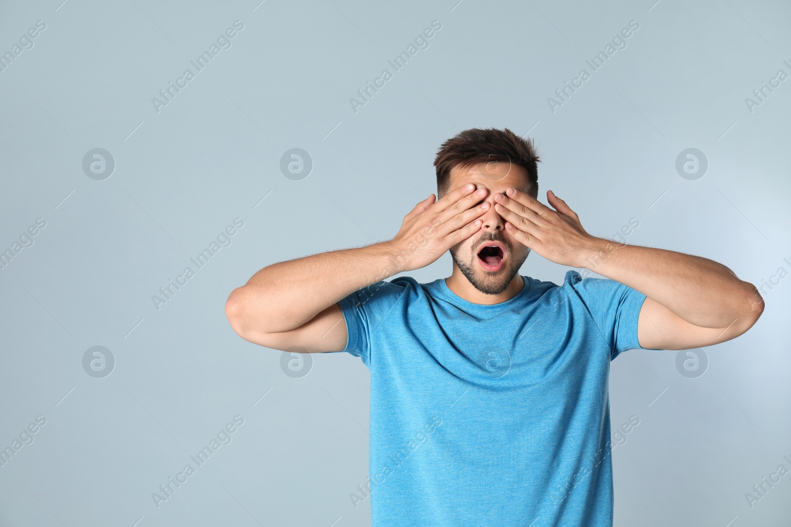 Photo of Young man being blinded on grey background, space for text