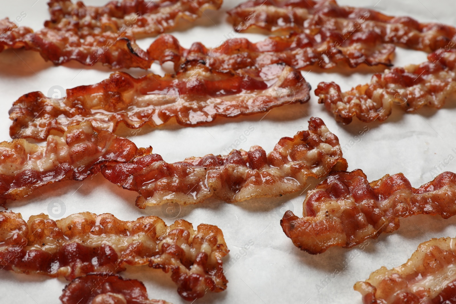 Photo of Slices of tasty fried bacon on white table