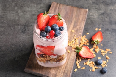 Mason jar with yogurt, berries and granola on table