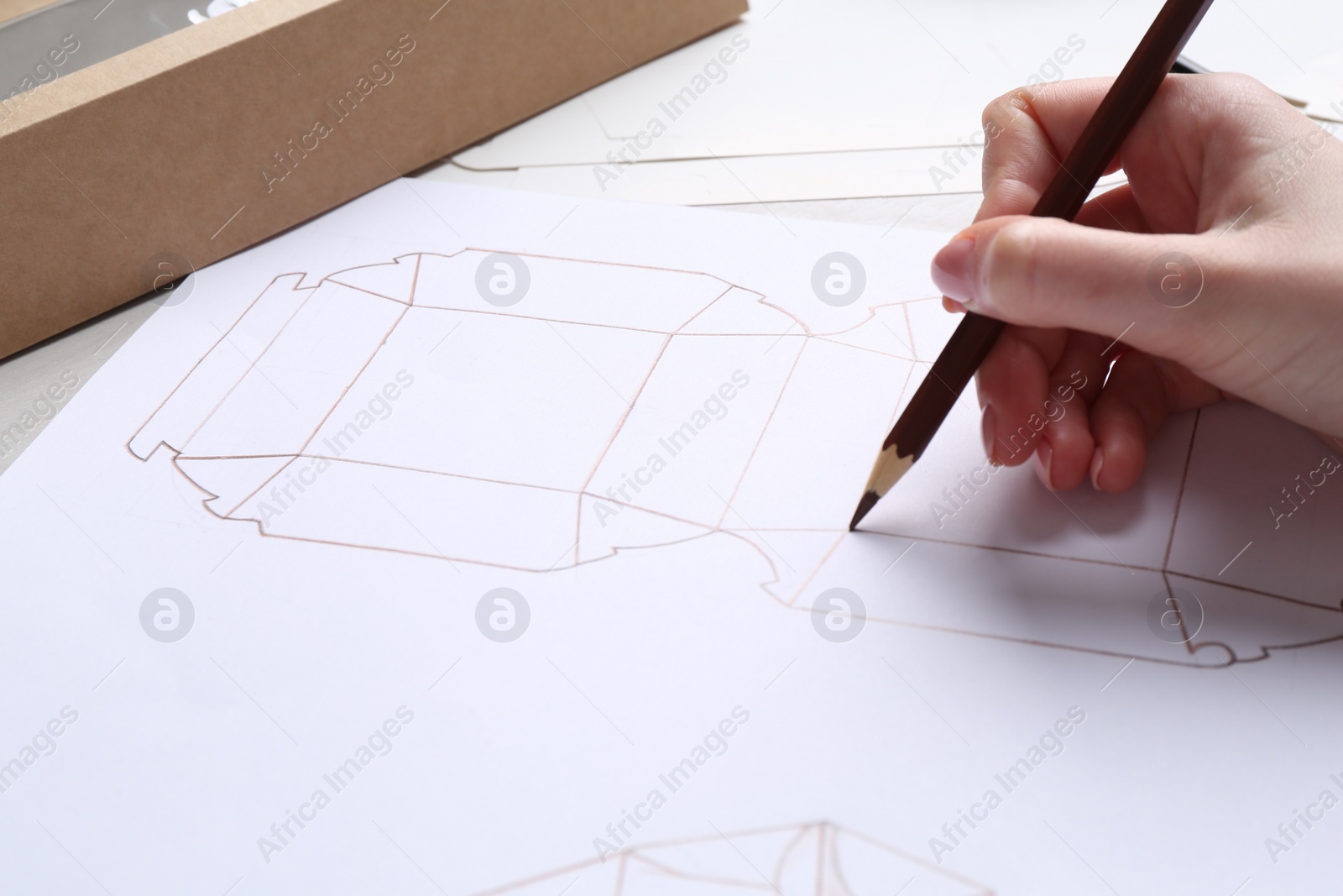 Photo of Woman creating packaging design at table, closeup