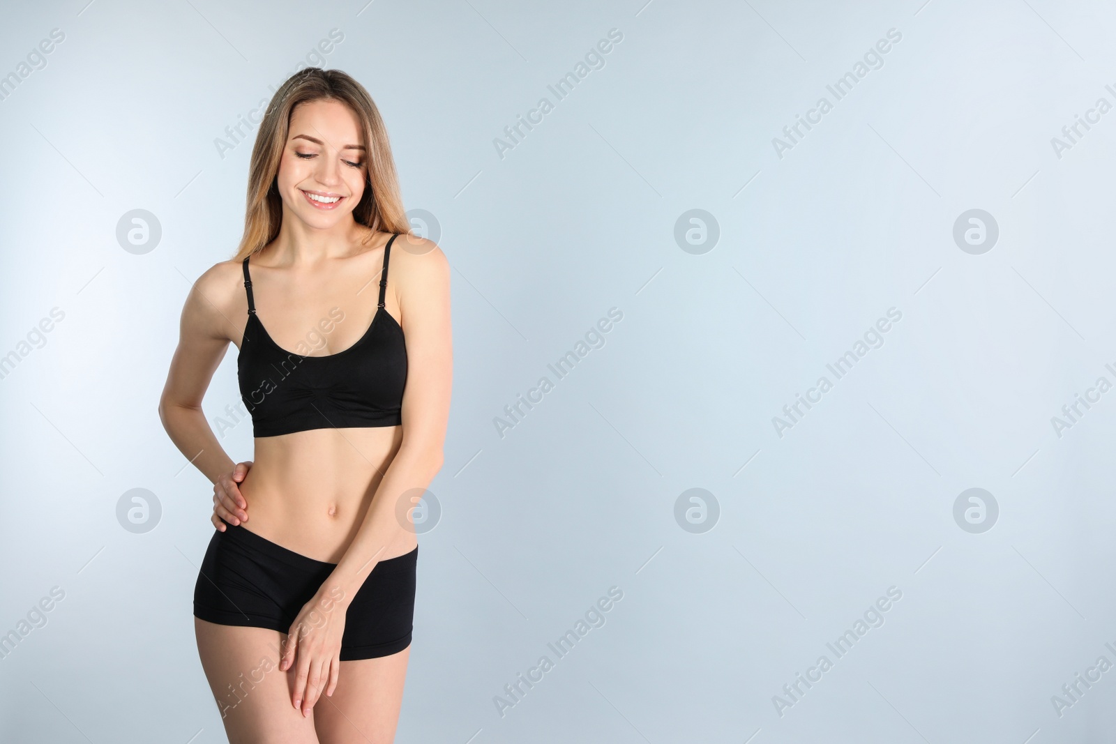 Photo of Young slim woman on light background, space for text. Perfect body