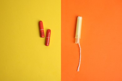 Photo of Regular and applicator tampons on color background, flat lay