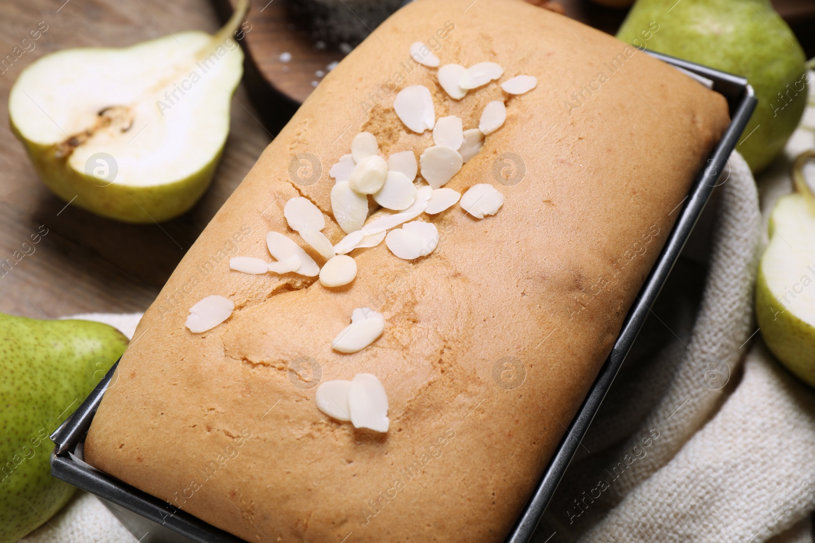 Photo of Tasty bread with almond flakes and pears on table, closeup. Homemade cake