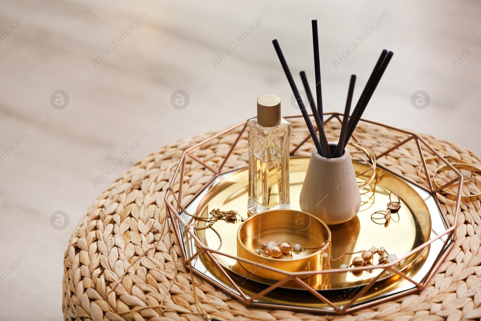 Photo of Composition with stylish accessories and interior elements on wicker pouf indoors