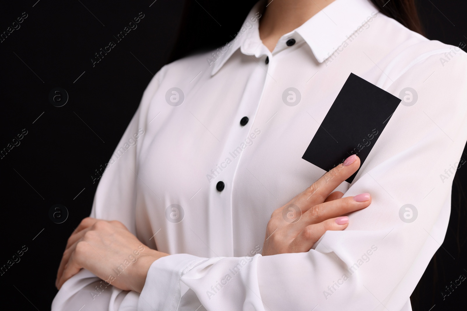 Photo of Woman holding blank business card on black background, closeup. Space for text