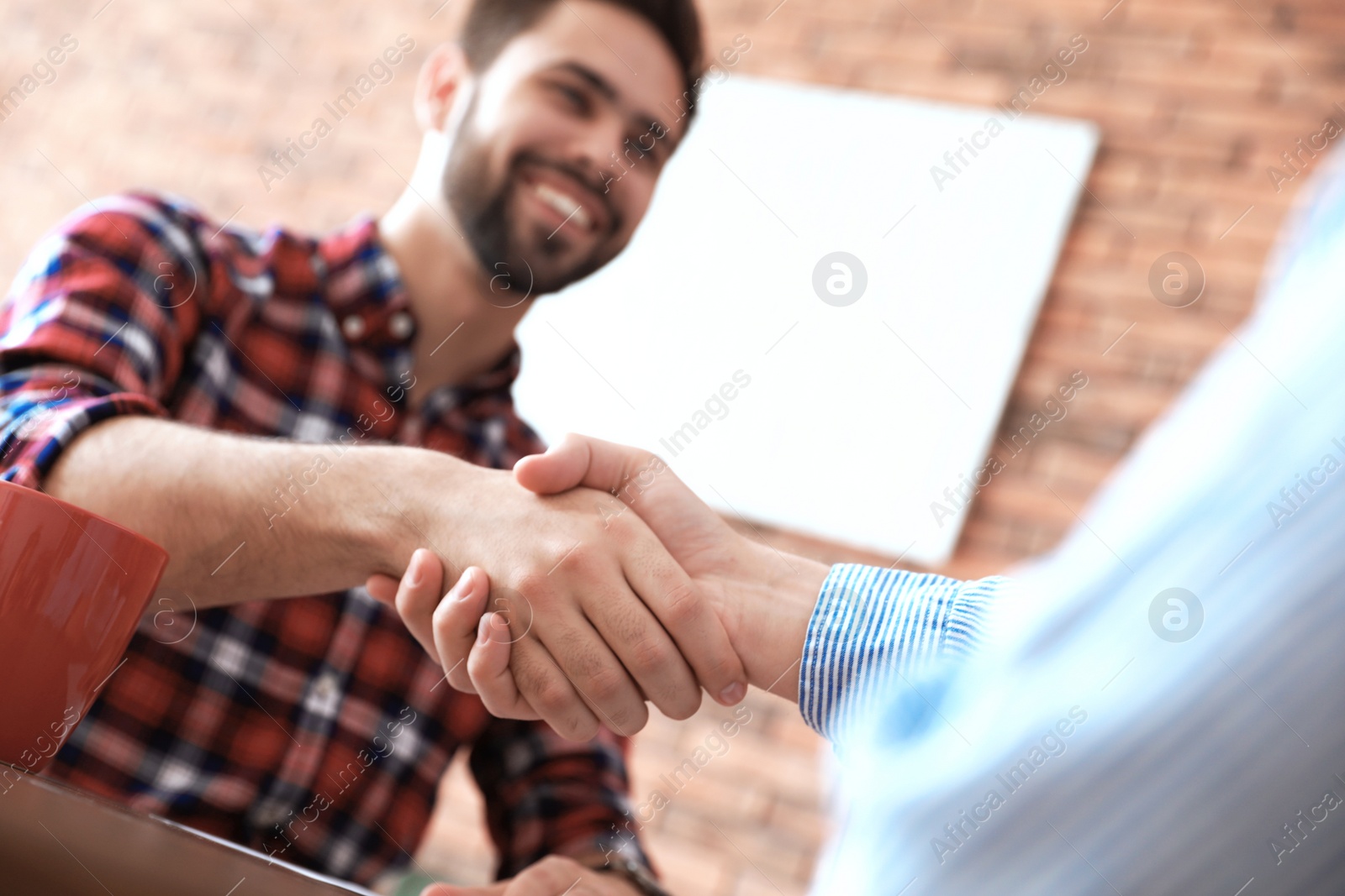 Photo of Business partners shaking hands after meeting, closeup