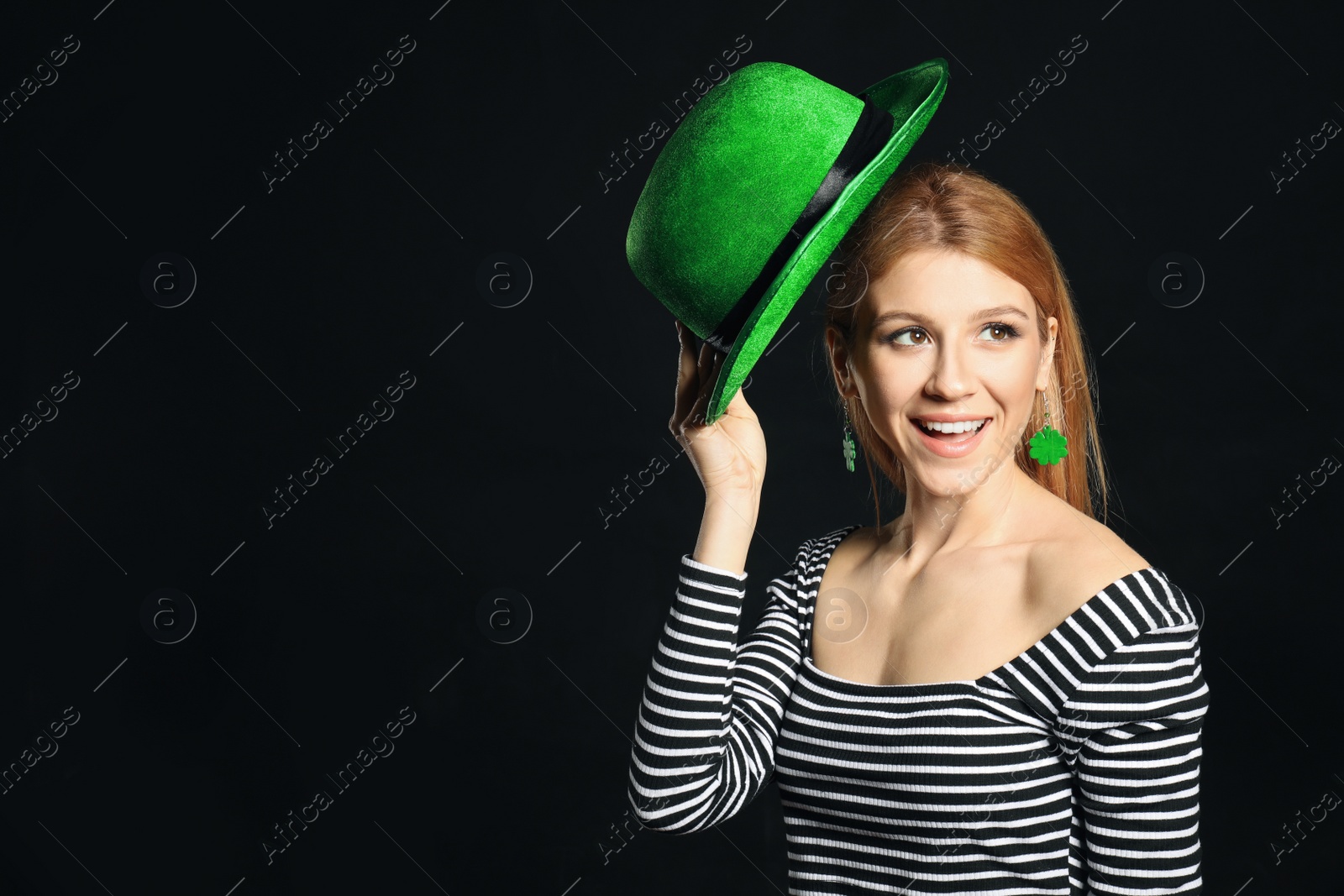 Photo of Young woman with green hat on black background, space for text. St. Patrick's Day celebration