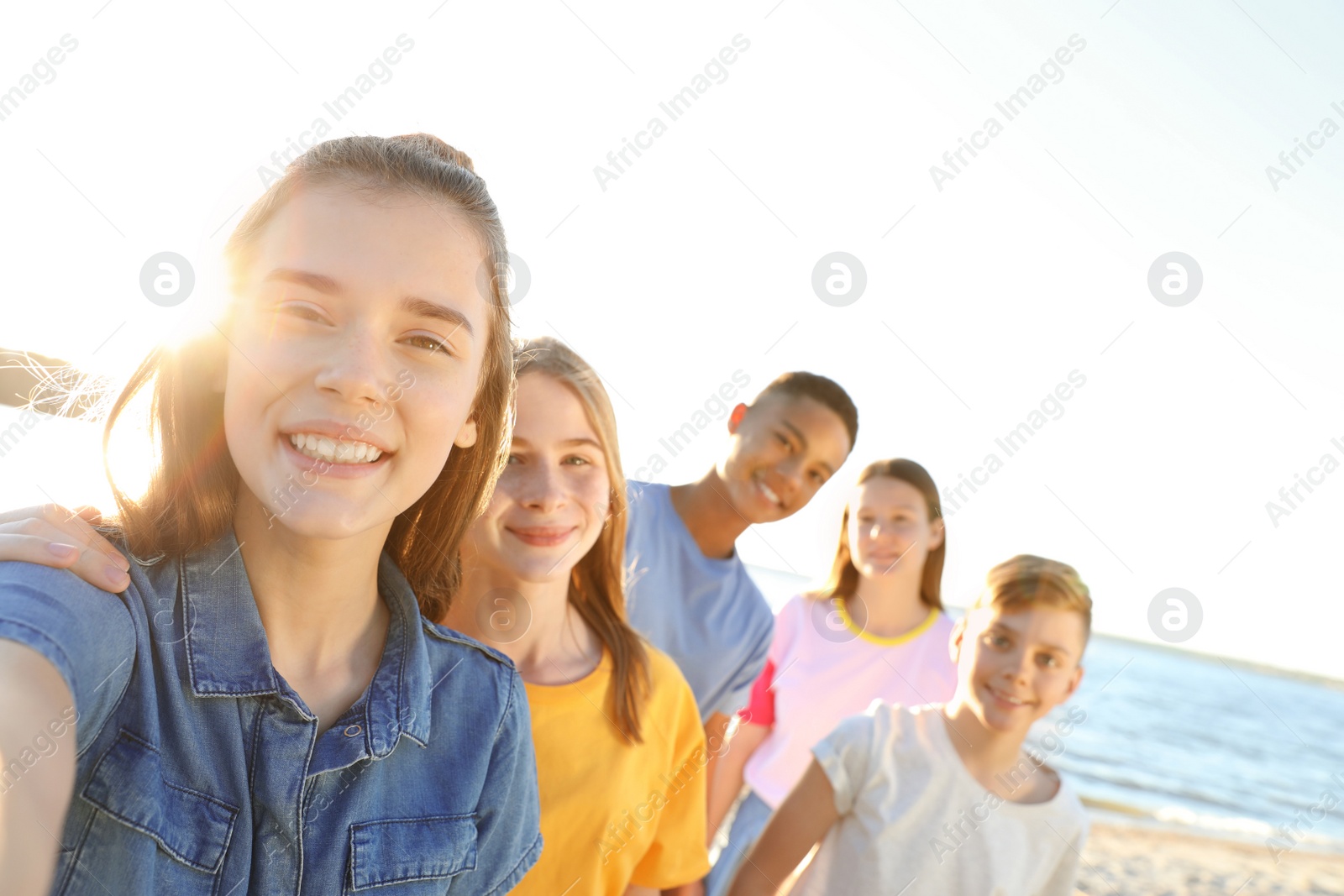 Photo of Group of children taking selfie on beach. Summer camp