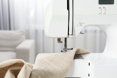 Photo of White sewing machine and fabric indoors, closeup